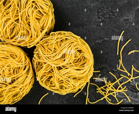 Uncooked Chinese Style Fine Egg Noodles Nests on a Black Slate Background Stock Photo - Alamy