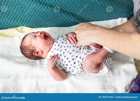 Loud Crying Baby with Abdominal Pain Laying on Bedsheet, Human Hands ...