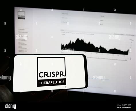 Person holding mobile phone with logo of biotechnology company CRISPR ...
