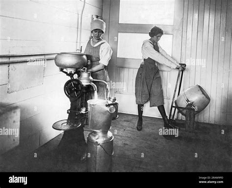 United States: c. 1920 Two women working in a dairy with one separating ...