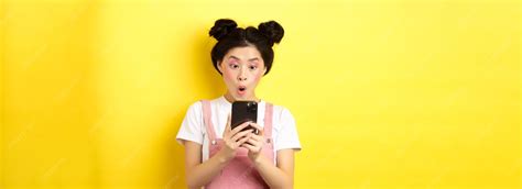 Asian teen girl look excited at smartphone screen reading news on phone ...