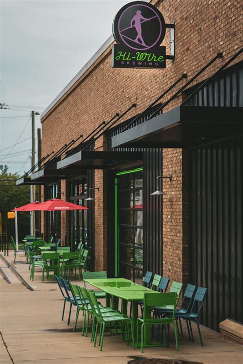 A row of tables and chairs outside of a building photo – Free Hi-wire ...