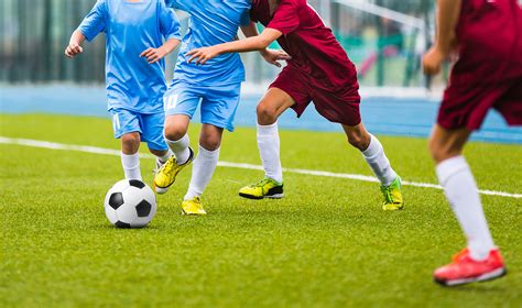 Young soccer players running towards soccer ball. Football soccer game ...