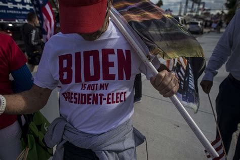 Supporters of Donald Trump hold signs and flags, cheering him