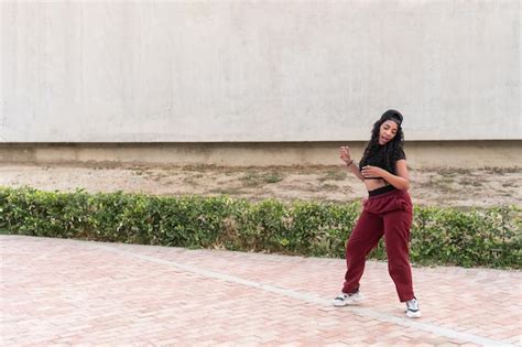 Young woman dancing outdoors in urban setting | Premium Photo