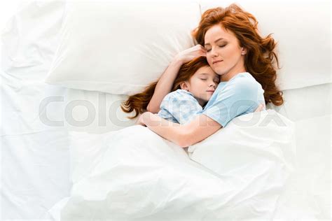 beautiful mother and daughter hugging and sleeping together in bed ...