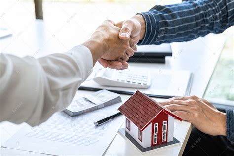 地产代理与客户在签订了房屋保险、投资贷款、握手及成功交易等协议后，携手庆祝合约的签订.高清摄影大图-千库网