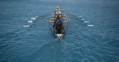 Pessoa em um barco com outra pessoa praticando snorkel ao lado do barco