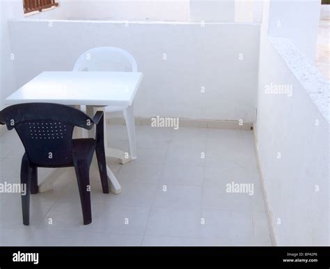 Plastic table and chairs on sun terrace balcony Stock Photo - Alamy