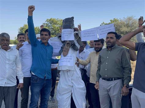 Farmers express anger by making a statue and garlanding it with shoes ...