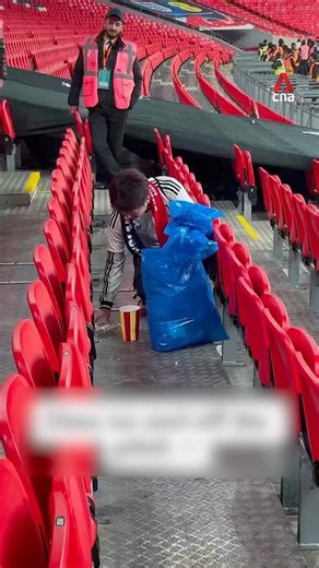 Japanese football fans clean up after themselves after Japan-England match