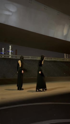 Women in Black Dresses Walking Under City Lights