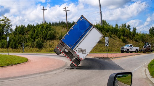 Speeding semi truck flips at a roundabout - caught on dashcam