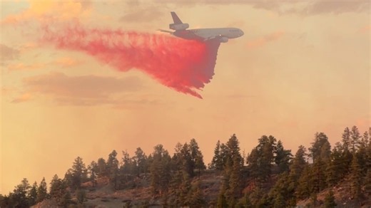Flames rage on tree covered hillside after truck fire