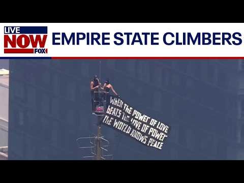 Couple flies banner atop Empire State Building spire