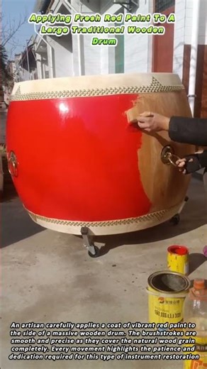 Applying Fresh Red Paint To A Large Traditional Wooden Drum