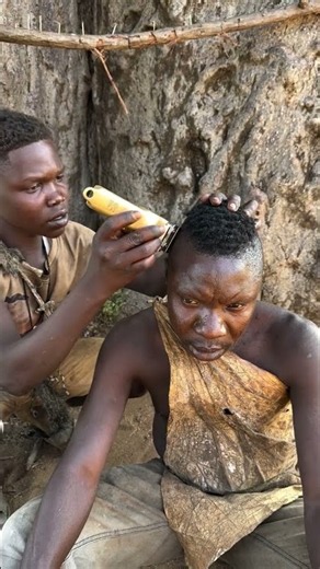 Hadzabe bushmen Chabba getting a fresh haircut in the bush