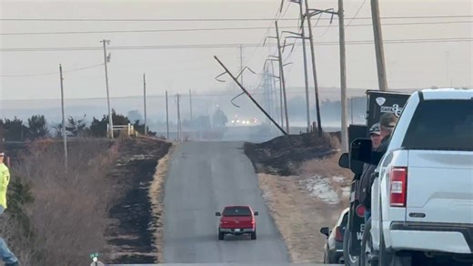 WILDFIRE south side of Woodward, Oklahoma still burning! This could be near where the fire started with these downed power poles. Looking east toward large active flames and smoke plumes. Appears to be some structures burned | Reed Timmer Extreme Meteorologist