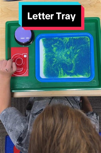 Here’s another hands-on letter tray for G! Students press the button to hear the letter name and sound, then use the hand2mind marble tracer to push the marble along the letter while saying its name and sound. Next, they try writing lowercase g on their own in the sand. They see it, here it, touch it.