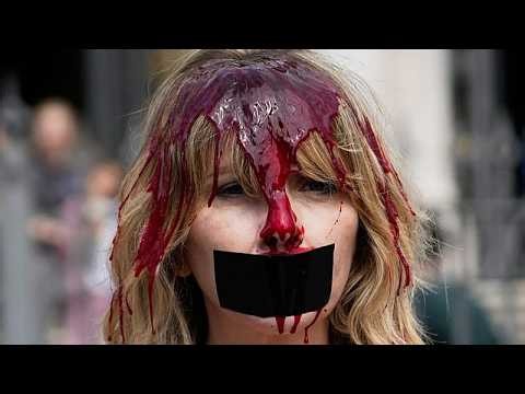 Activists covered in red paint protest bullfighting in Pamplona