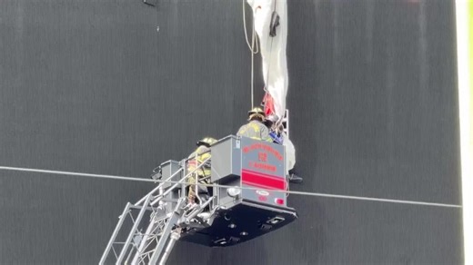 Un parachutiste visant le terrain d’un stade termine sa descente sur le tableau d’affichage - images de CNN