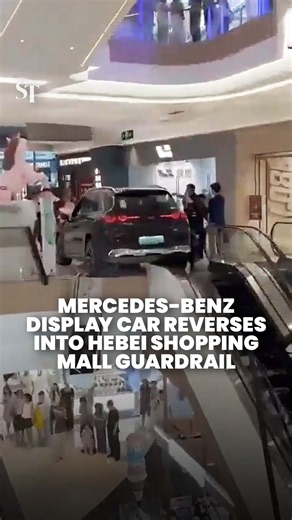 Display car left hanging after reversing into guardrail at shopping mall in Hebei