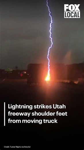 Lightning strikes freeway shoulder feet away from moving truck