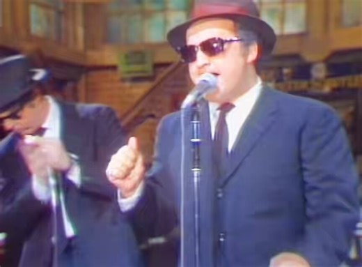 On this day in 1978, John Belushi and Dan Aykroyd debuted as the Blues Brothers on Saturday Night Live. Dan Aykroyd was a serious blues fan and introduced John Belushi to blues music backstage at SNL. The ‘Blues Brothers’ concept came together as a parody and tribute: two white guys fully committing to classic Black American blues and soul traditions.Their performances stood out because they weren’t just sketches, they were full-on musical numbers and the audience loved it. The Blues Brothers!