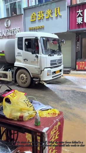 Water Truck Washing Mud Streets After Flood