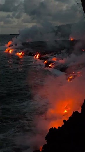 Lava flow meets ocean during eruption near Sainte‑Rose, Réunion, France