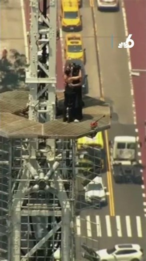 1 climber appears to propose to the other atop Empire State Building