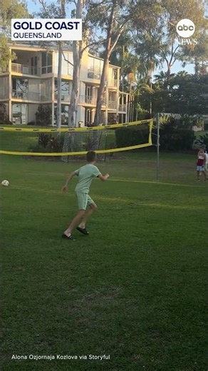 Boys play ball with kangaroo at Australia resort