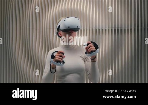 Caucasian futuristic woman in virtual reality helmet playing vr boxing game holding controllers in futurism gaming club concentrated girl female in white room online simulation cyberpunk metaverse Stock Video Footage - Alamy