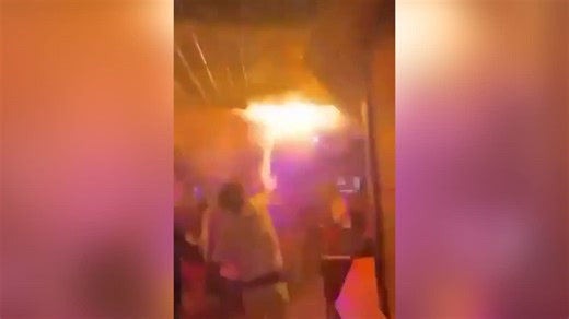 Moment partygoer tries to stop flames as deadly fire breaks out in Swiss bar