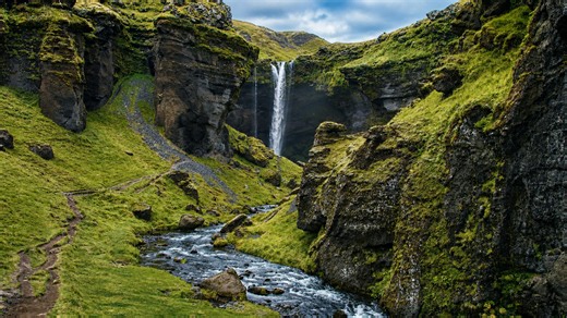 This waterfall cuts through Iceland’s green cliffs