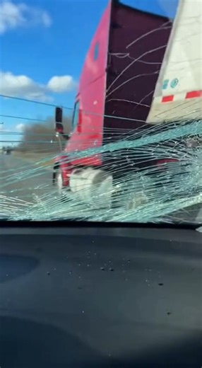 Truck Tire Explodes, Smashes Through Windshield of Passing Car in Freak Highway Accident Cook County, Illinois — December 22, 2025 Shocking dashcam footage captures the terrifying moment a truck tire suddenly blows out, launching debris that smashes directly through the windshield of a nearby car traveling at highway speed. The video shows the truck cruising in the adjacent lane when the tire violently disintegrates without warning. Large chunks of rubber and metal fly across lanes, with one mas