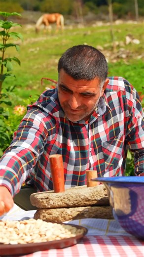 Whole grains ground and mixed with care outdoors, creating a warm, comforting paste cooked slowly over open fire. #TraditionalCooking #OutdoorCooking #NaturalIngredients #Cooking | FV Stories