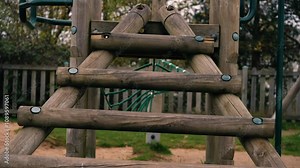 Wooden play ladders in sand pit in childrens adventure playground park