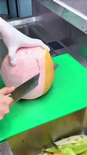 Peeling a Large Pomelo with a Sharp Cleaver on a Cutting Board