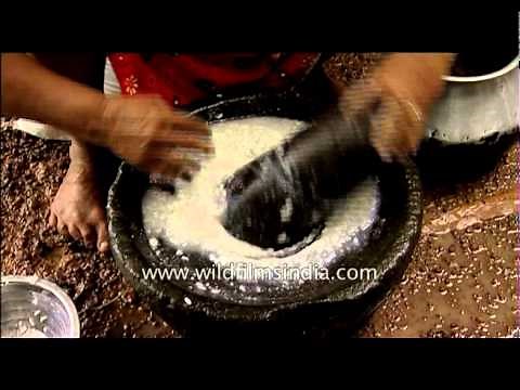 Traditional process of rice grinding with a stone