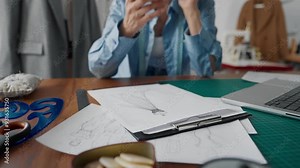 Fashion designer woman sketching dress in work studio of atelier, closeup. Professional tailor drawing new model of gorgeous gown on paper, fashion business and trendy clothes brand, businesswoman