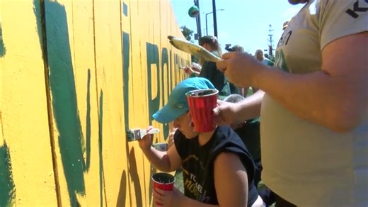 Packers fans continue tradition, paint new slogan on the Original Packer Fence