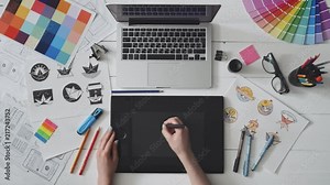Creative designer using graphics tablet while working at her table