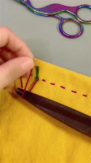 Using rainbow colored scissors to cut sewing thread