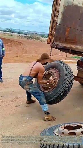 Bouncing the Load: How a Worker Uses Momentum to Mount a Heavy Truck Tire