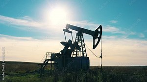 Working oil pump jack at work in the oilfield. Oil industry, crude oil prices concept.