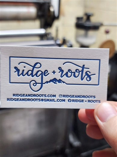 A little snippet from the press while restocking business cards for Gina of @ridgeandroots ✨️ These cards are letterpress printed on cotton paper using photopolymer plates on a Heidelberg Windmill printing press. They are then cut down on a challenge paper cutter. . . . . #letterpress #printing #businesscards #heidelbergwindmill #stationery
