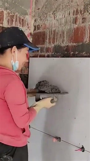 A cement dough that is being flattened to install ceramics on a building