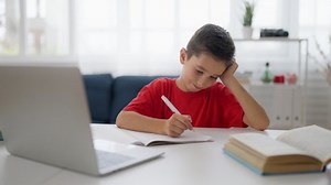 Thoughtful schoolboy having difficulty with homework, complicated math problem
