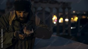 hunger, marginalization, charity- beggar controls his alms in the night